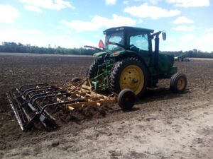 Chisel plow being used on an empty field.